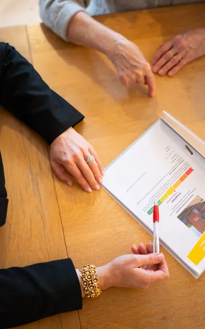 Vastgoedmakelaar die contract bespreekt met vrouw