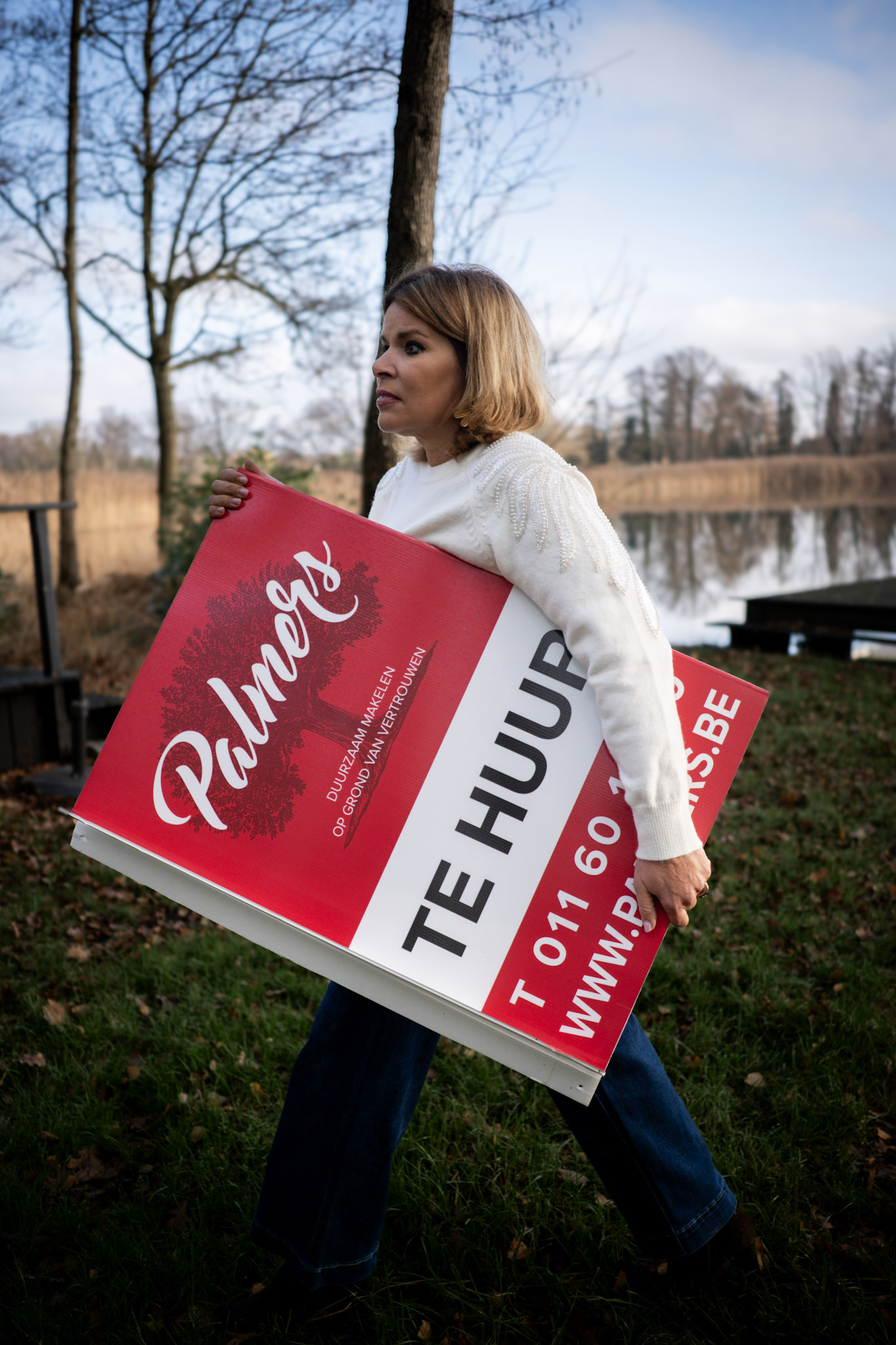 Vrouw met plakaat waarop te huur staat