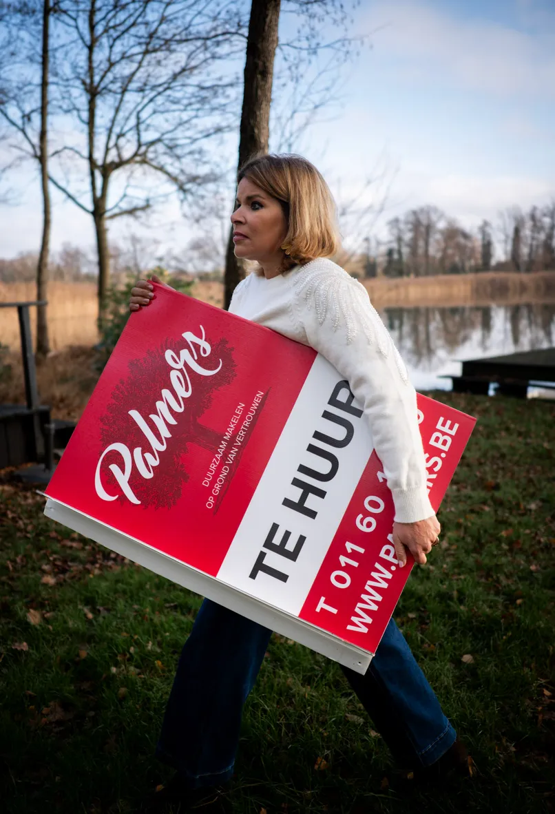 Vrouw met plakaat waarop te huur staat